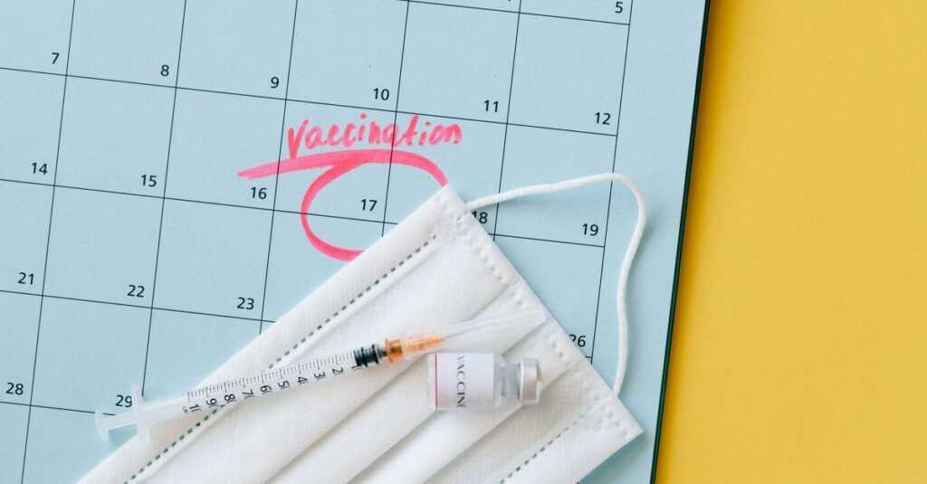 Close-up of a calendar marked for vaccination with a syringe and face mask