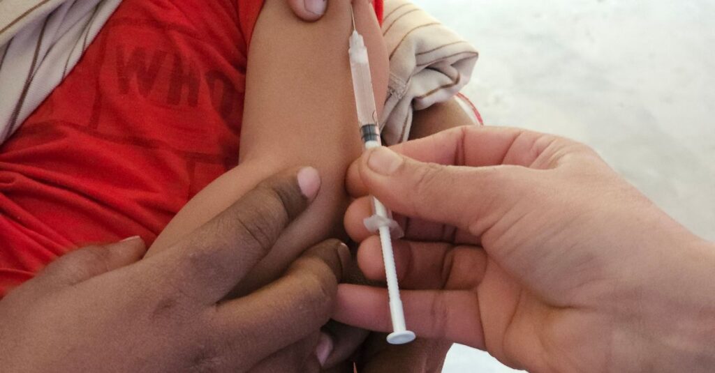Child receiving a measles vaccination from a healthcare professional