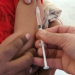 Child receiving a measles vaccination from a healthcare professional