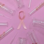 Pink ribbon and laboratory glassware representing breast cancer research