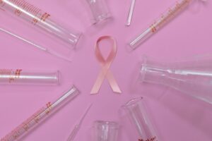 Pink ribbon and laboratory glassware representing breast cancer research